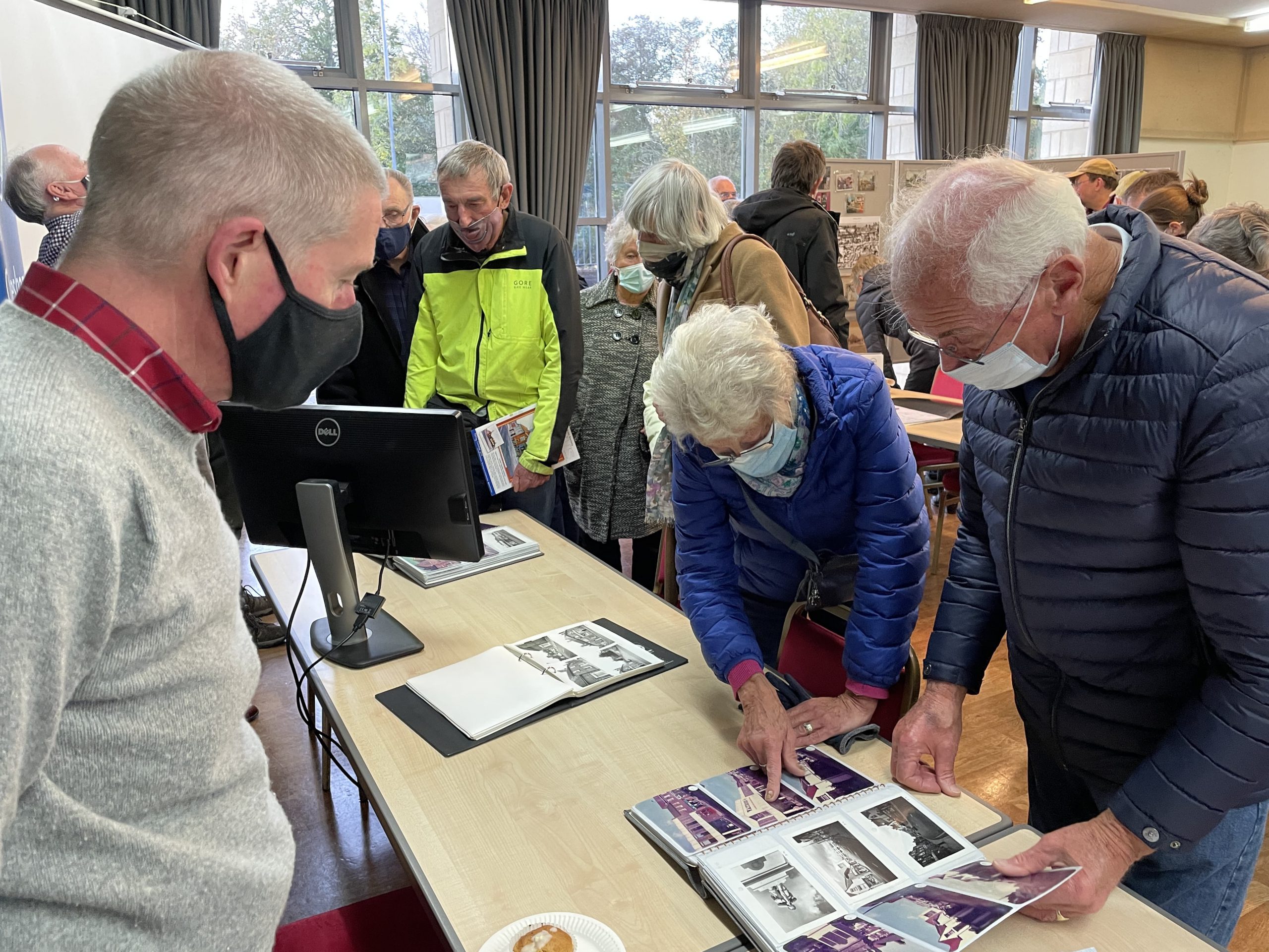 People viewing a book of images at an event